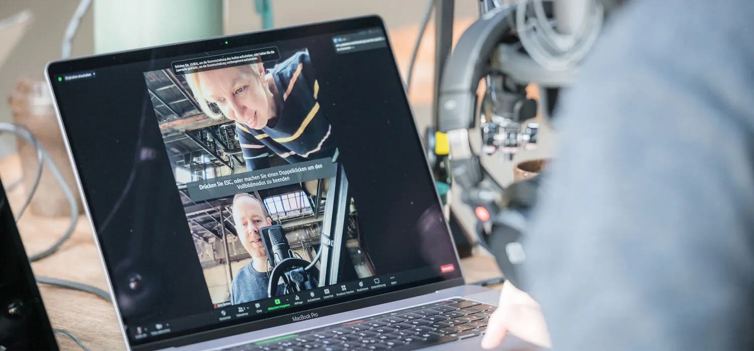 Zoom-Aufnahme von Manuela und Arto auf einem Laptop neben dem Mikrofon